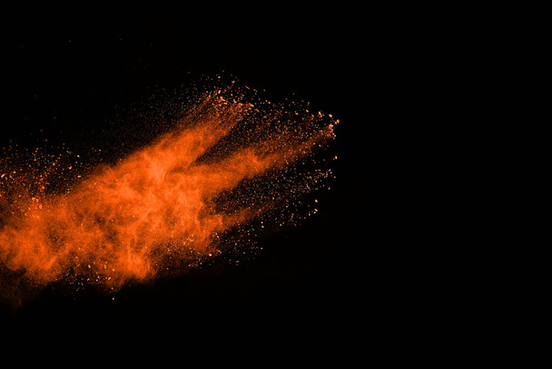 Orange powder explosion on black background. Colored cloud. Colorful dust explode. Paint Holi. - Photo, Image