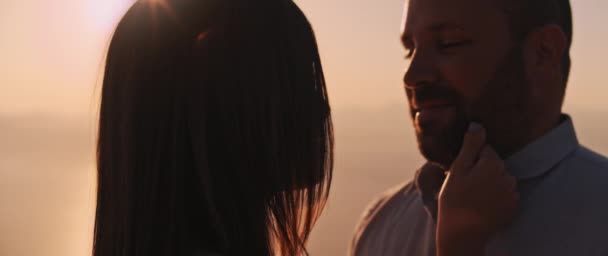 Een jonge vrouw raakt het gezicht van haar vriend aan terwijl ze een romantische avond samen doorbrengen, elkaar aankijkend met liefde. Close up, slow motion.  - Video