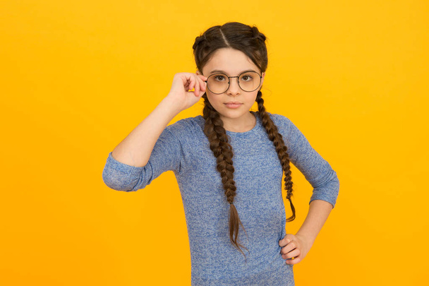 Choosing trendy glasses perfect for her style. Little child wear eyeglasses yellow background. Small girl in casual style. Fashion style. Stylish eyewear. Beauty look. Hair salon. Exciting style - Fotoğraf, Görsel