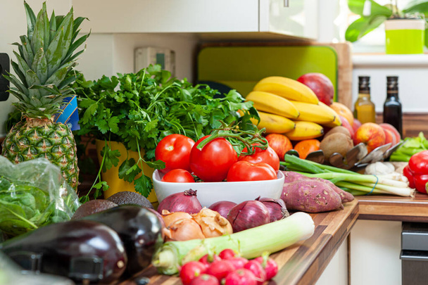 Abundancia de verduras frescas y frutas en la encimera de la cocina
. - Foto, imagen