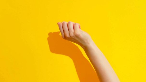 Top view of a fist of a woman on a yellow background - Photo, Image