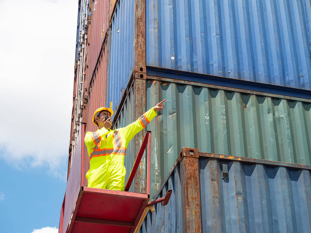 Inspection engineer using radio communication for communication to control the transportation of products through containers on the job site. - Photo, Image