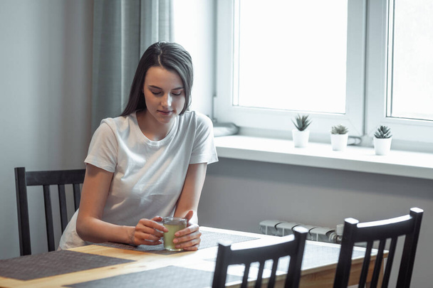 beautiful young woman drinking hot beverage. Attractive girl relaxing at home - Fotoğraf, Görsel