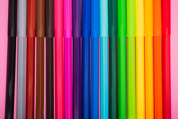 vista superior da fileira multicolorida canetas de feltro no fundo rosa
 - Foto, Imagem