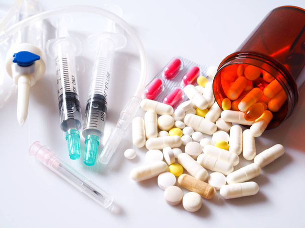 Medische en medische kits met pillen, zoutbuisjes en naalden geïsoleerd op witte achtergrond. - Foto, afbeelding