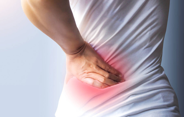 Fiatal ázsiai nő szenved alacsony hátfájás és deréktáji ágyéki fájdalom. - Fotó, kép