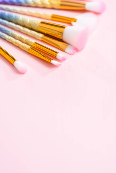 Unicorn color makeup brushes on a pink background. - Foto, imagen