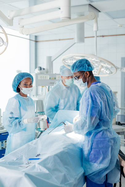 african and caucasian doctors perform the risky surgery - Fotoğraf, Görsel