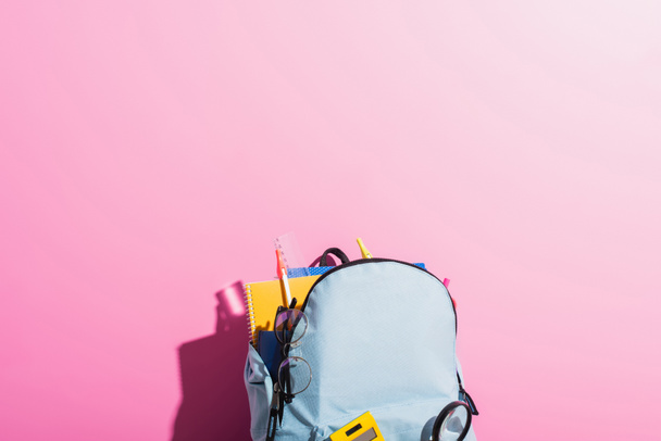kék hátizsák iskolai levélpapírral és szemüveg rózsaszín - Fotó, kép