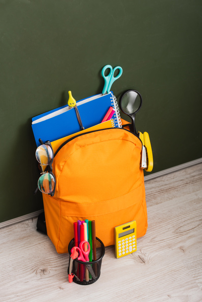 magas látószögű kilátás sárga hátizsák iskolai kellékek közelében számológép és tolltartó - Fotó, kép