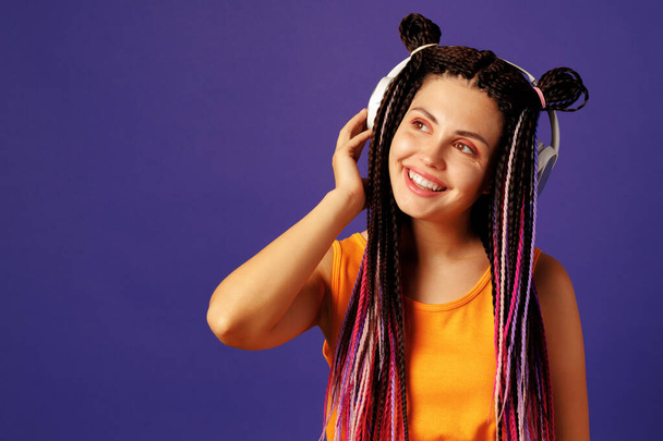 Young caucasian woman with african cornrows listening to music with headphones - Foto, Imagen