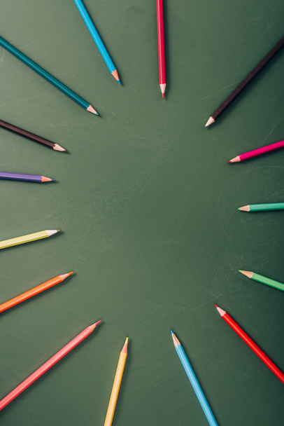 top view of empty frame of color pencils on green chalkboard - Fotografie, Obrázek