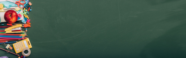 vista superior de maçã madura e artigos de papelaria escolar em quadro-negro verde, imagem horizontal
 - Foto, Imagem