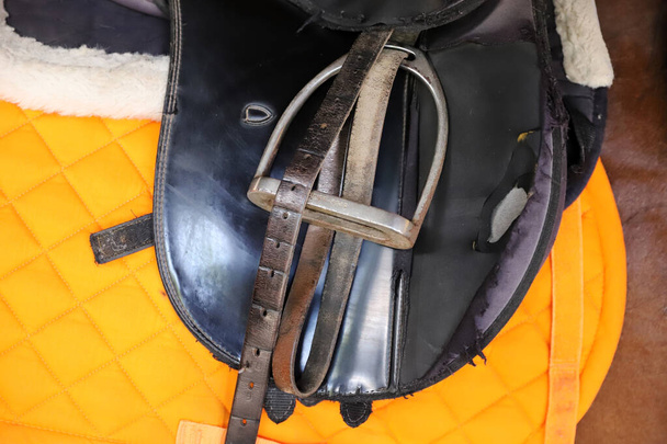 スポーツ馬を閉じると、古い革のサドルは、ドレッジトレーニングのために準備。馬術競技の背景 - 写真・画像