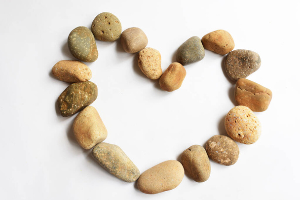 Zen stones in a heart-shaped form in white background, rock pebbles heart shape, Love symbol, valentine day, love concept, zen and meditation, zen, abstract spa background - Photo, Image