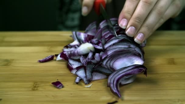 ahşap masa üzerinde küçük parçalar halinde dilimlenmiş soğan dilimleri kesmek - Video, Çekim