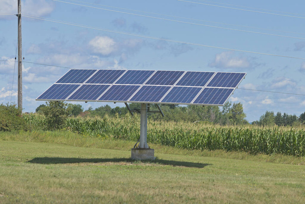 青い空の反対側のフィールド内の太陽電池パネル  - 写真・画像