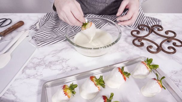 Pas à pas. Tremper les fraises biologiques dans un bol avec du chocolat fondu pour préparer des fraises recouvertes de chocolat. - Photo, image