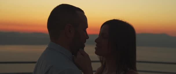 Nahaufnahme eines jungen Paares, das sich bei Sonnenuntergang mit Liebe betrachtet. Bogenschuss, Zeitlupe.  - Filmmaterial, Video