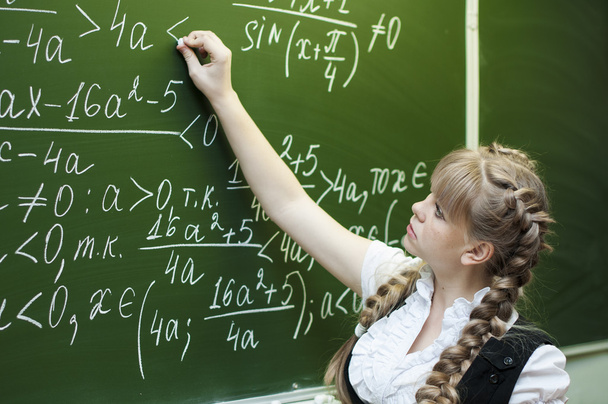 Schoolgirl at the blackboard writes - Foto, Imagen