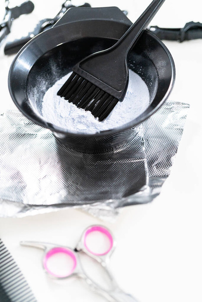 Hair color dye powder in a black plastic mixing bowl on a white background. - Photo, Image