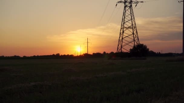 Hoogspanningstransmissielijn bij zonsondergang of zonsopgang. Transmissie van hernieuwbare energie. Transmissietorens met hoog vermogen. - Video