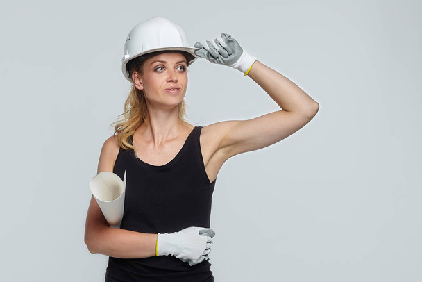 blonde woman in construction helmet points to blank field for text placement - Foto, afbeelding