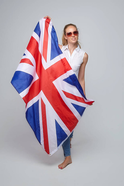 blonde girl. posing with uk flag in studio on white background - Fotoğraf, Görsel