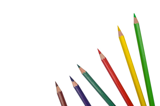 Six various colored wood pencil crayons placed on a white isolated paper background - Photo, Image