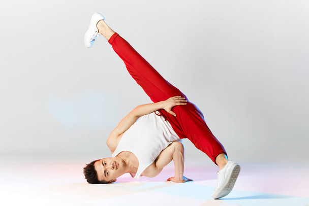 A man hip hop dancer or bboy freezes in one pose on the hand - Photo, image
