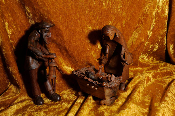 nativity scéna v době Vánoc, dřevěné postavy na zlaté přikrývce - Fotografie, Obrázek