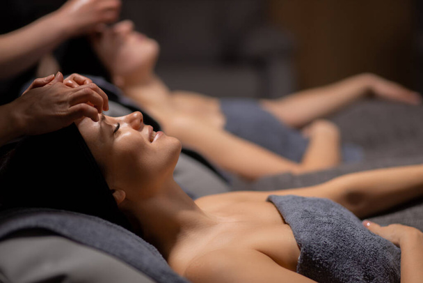 two attractive women get facial massage - Фото, изображение