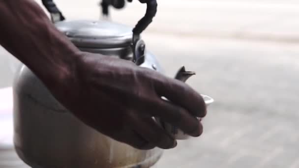 Hagyományos Tanzániai utcai fekete kávé alumínium teáskannában. Kávé öntés egy kis fazék Dar Es Salaam. - Felvétel, videó