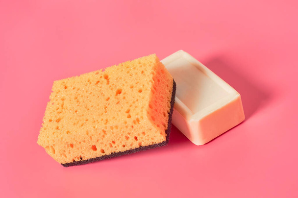Brick of soap near sponge on pink background. Hygiene and cleaning concept - Fotoğraf, Görsel