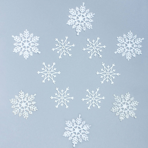 white decorative snowflakes on a gray background. Christmas and New Year, a place for text, minimalism, winter background - Фото, изображение