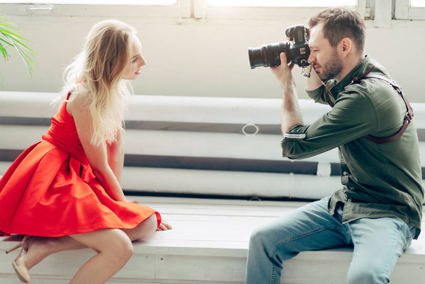 amateur photographer working with beautiful girl in red dress - Valokuva, kuva