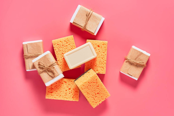 Heap of bricks of soap in vintage packing and sponges on pink background. Hygiene and cleaning concept - Foto, immagini