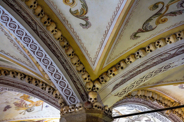 0831 Deckendetails aus Schädeln kontrastieren traditionelle Architektur mit den Skelettresten in der Kapelle der Knochen - Evora, Portgual - Foto, Bild