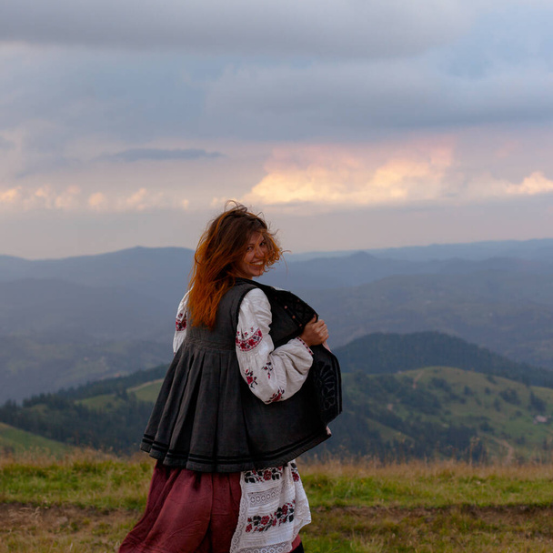 attractive girl in Ukrainian embroidery high in the carpathian mountains - Fotoğraf, Görsel