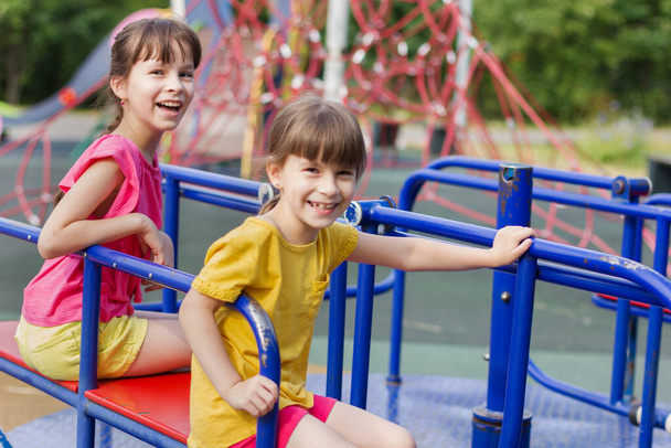 two little girls laughting on a playground - Valokuva, kuva