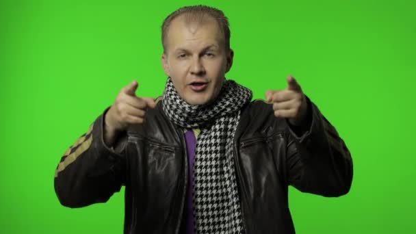 Handsome positive rocker man in brown denim jacket pointing finger at camera. Chroma key - Footage, Video