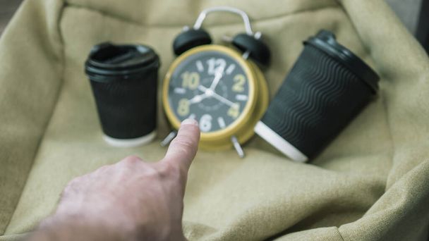 Pointing with a finger at a clock,time,plastic coffee cups,blurred background.Retro clock - Foto, Imagem