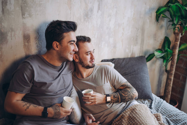 Perfect morning begins with lover and coffee in bed. Two guys resting in bed. - Foto, immagini
