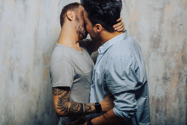 Cay couple enjoy togetherness indoors, kiss each other - Fotografie, Obrázek