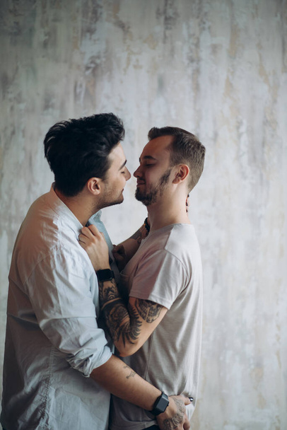 Cay Paar genießt Zweisamkeit drinnen, küsst einander - Foto, Bild