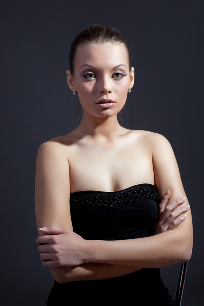 Charming slim model posing in black cocktail dress - 写真・画像