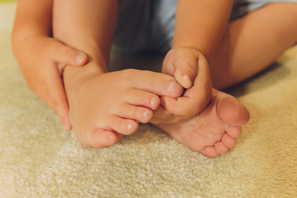 Childrens bare feet. Childs bare feet on the wooden floor. - Photo, Image