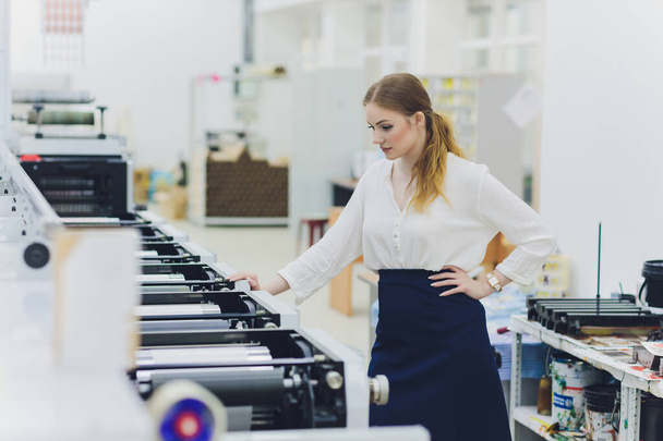 Young woman working in printing factory. Printing Press. - Φωτογραφία, εικόνα