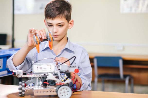 Kleiner Junge in Robotikschule baut Roboter - Foto, Bild