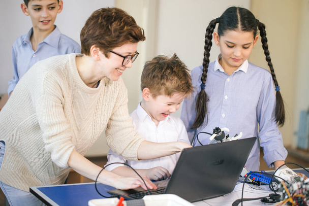 Crianças felizes aprendem programação usando laptops em aulas extracurriculares
 - Foto, Imagem